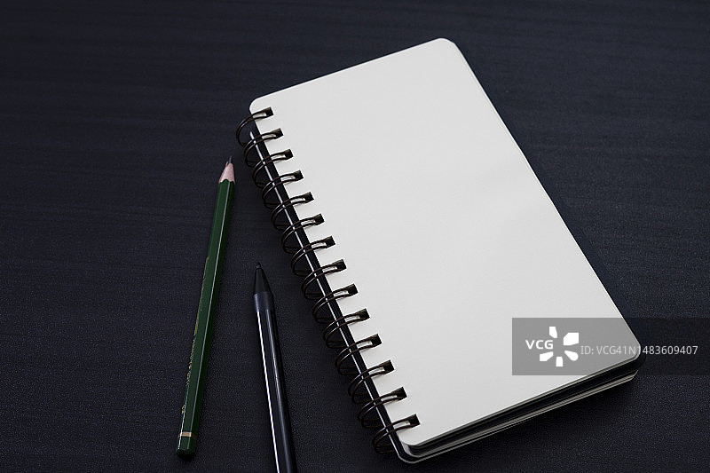 桌子上有笔记本和铅笔的黑色书桌，罗马尼亚图片素材