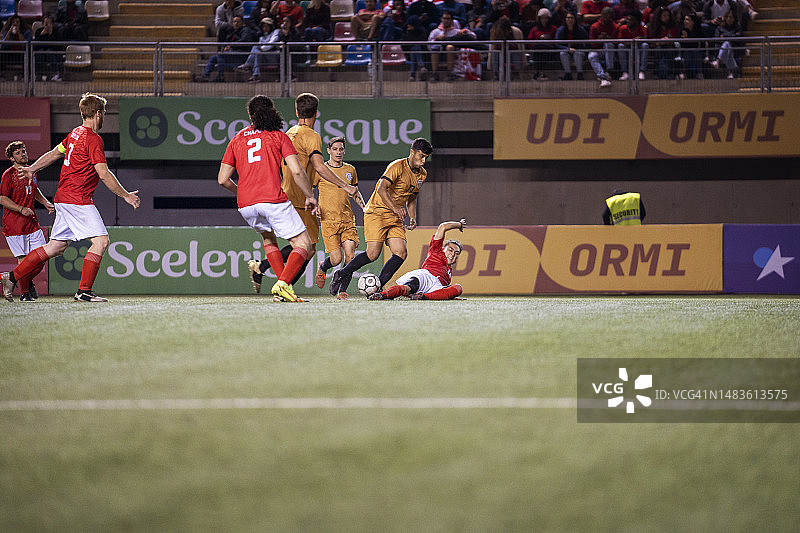 足球运动员在激烈比赛中滑铲抢球图片素材