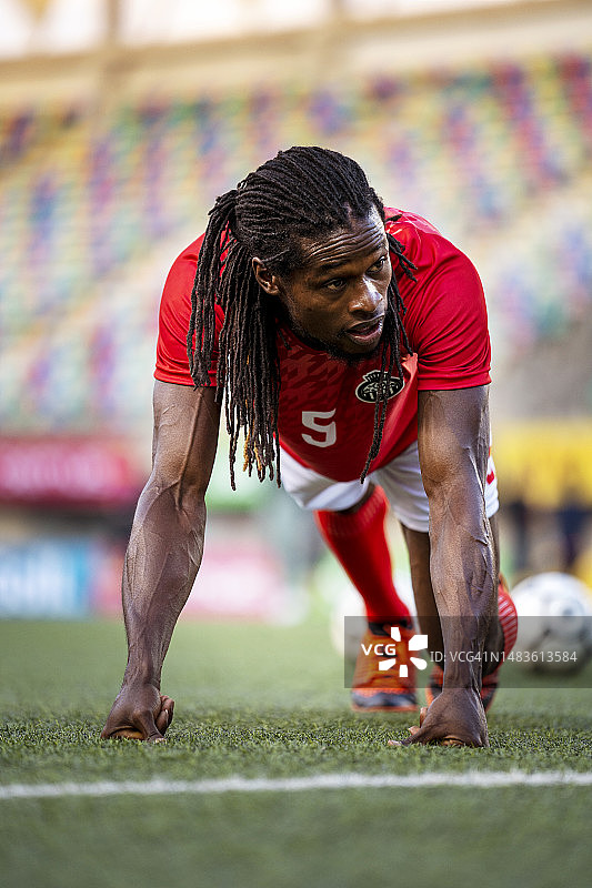 成年男子足球运动员在热身运动中做俯卧撑图片素材