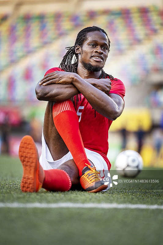 职业足球运动员赛前在球场上微笑和伸展身体图片素材