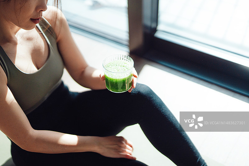 饮用绿色果汁和练习瑜伽的晨间习惯图片素材