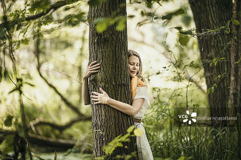 森林里拥抱树木的女人图片素材