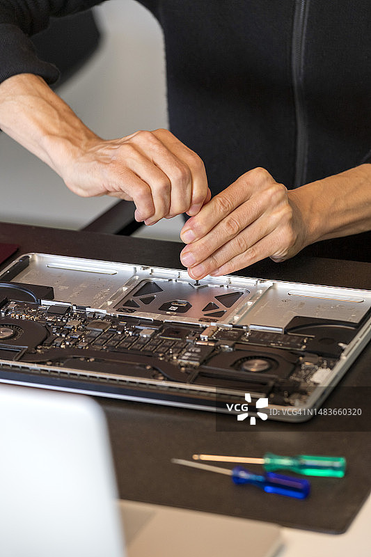 男子修理笔记本电脑图片素材