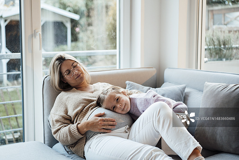 可爱的女孩在家将头靠在孕妇的肚子上休息图片素材