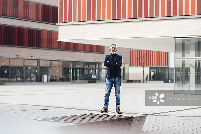 在建筑物前交叉双臂的商人图片素材