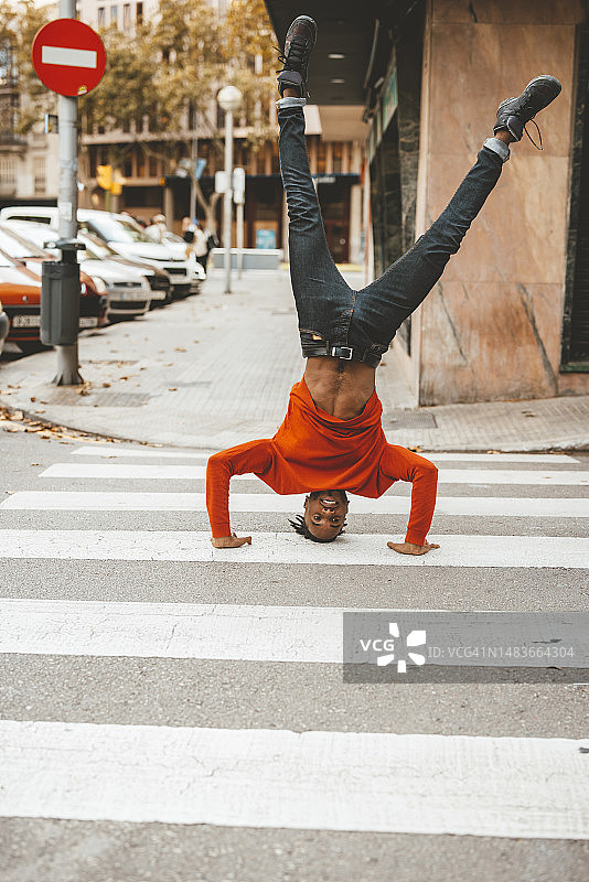 在斑马线上倒立的快乐年轻人图片素材