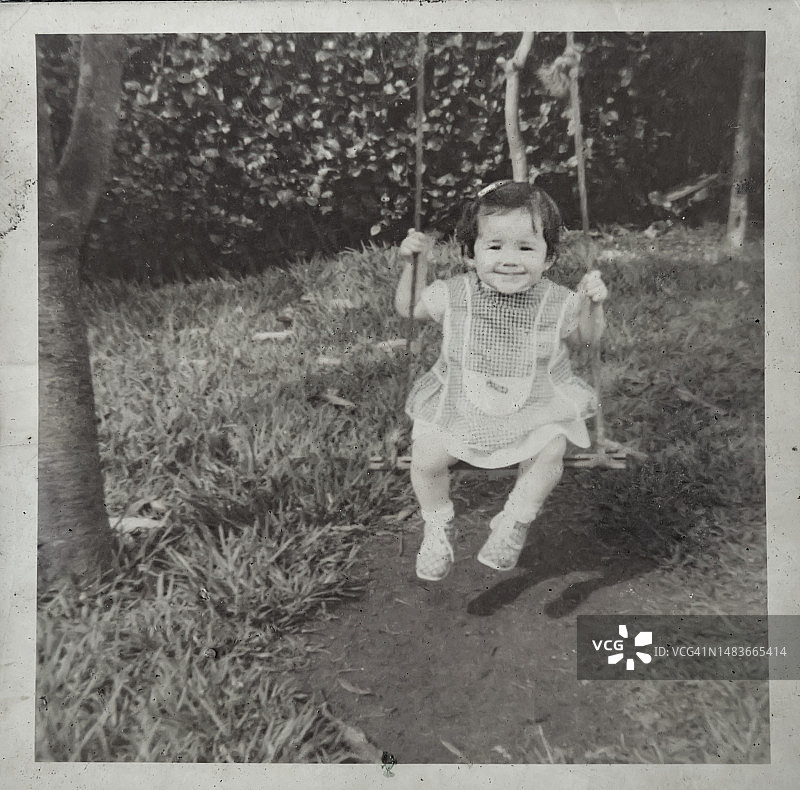 坐在花园秋千上的小女孩复古肖像图片素材