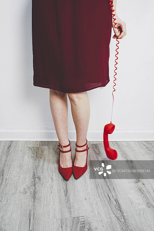 女人拿着红色电话听筒图片素材