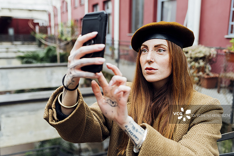 红发女人用智能手机自拍图片素材