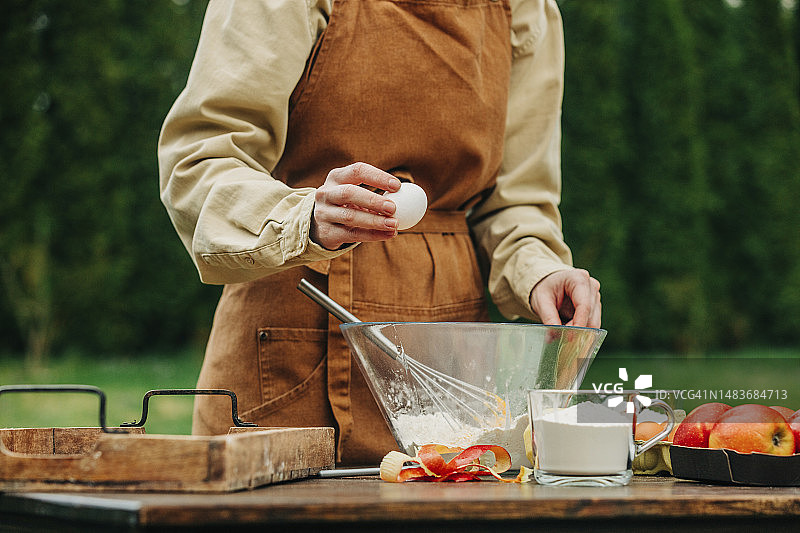 穿着围裙在花园里打鸡蛋的女人图片素材