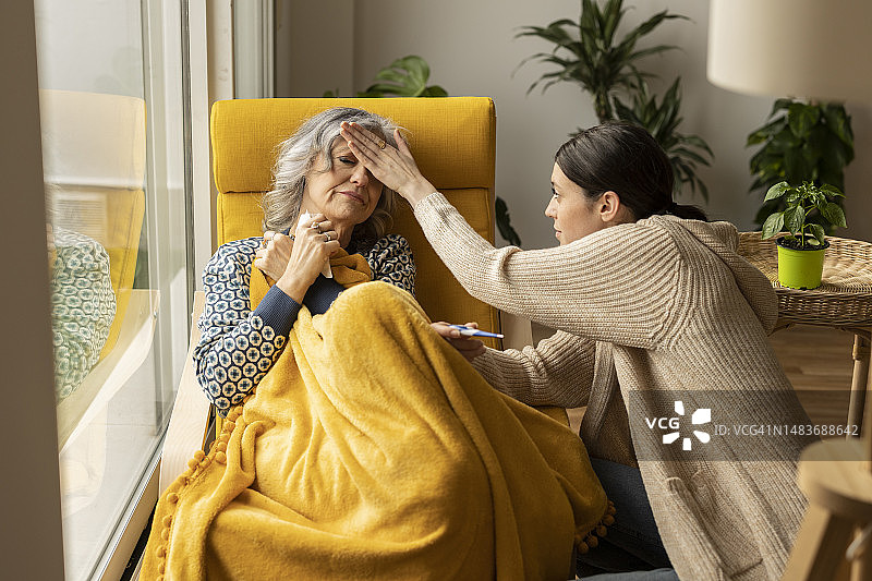 女儿在家中检查生病母亲的体温图片素材