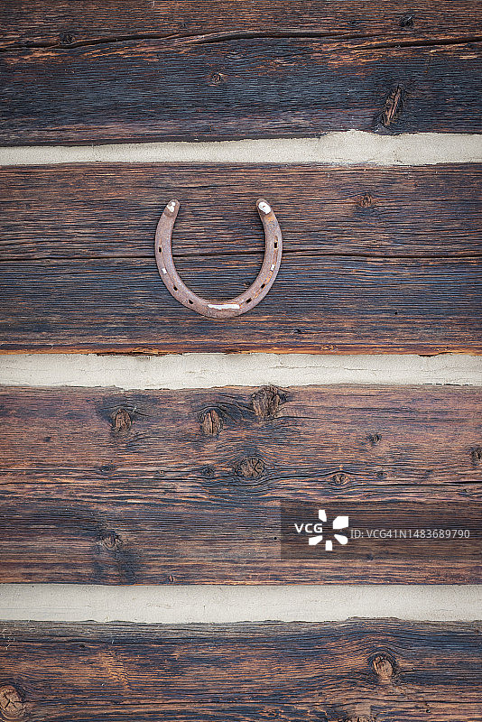 安装在乡村原木墙上的马蹄铁图片素材