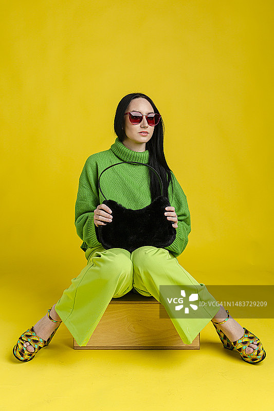 时尚的女人在朴素的背景前图片素材