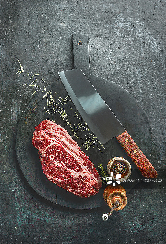 生鲜大理石纹牛肩眼肉牛排，黑色砧板图片素材