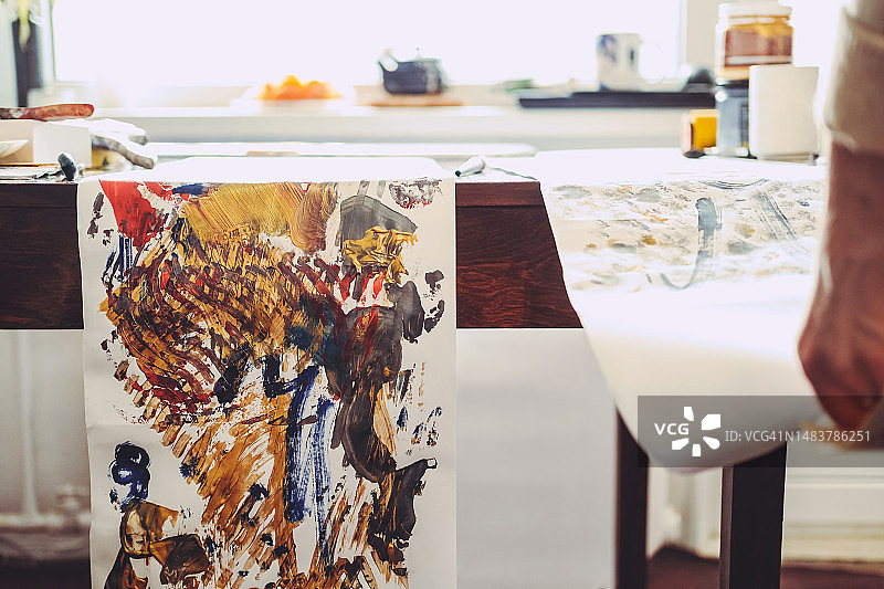 一个人拿着抽象画旁的画作图片素材
