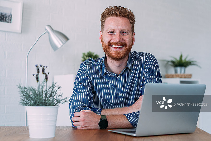 在现代办公室使用笔记本电脑的成功商人图片素材