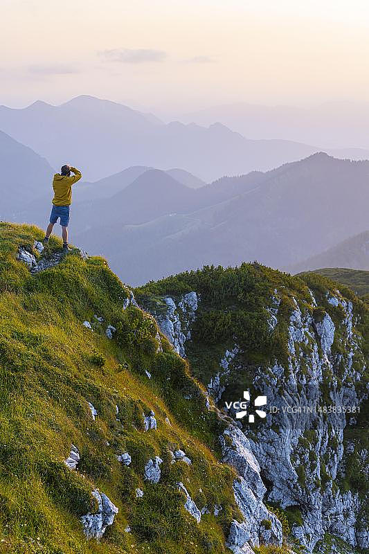 摄影师在贝内迪克滕万德峰顶日落时拍摄，背景是巴伐利亚阿尔卑斯山图片素材