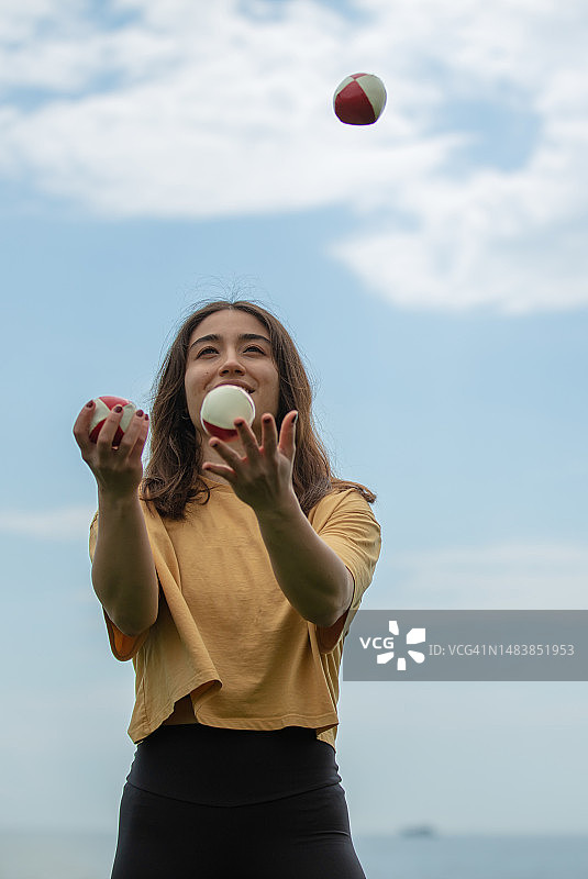 蓝天下的年轻女杂耍演员图片素材