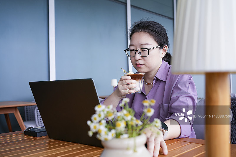 一位亚洲女人在户外办公室享用咖啡图片素材