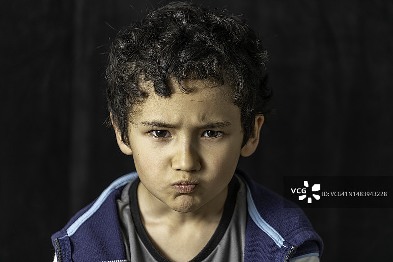 深色背景下的年轻混血男孩图片素材