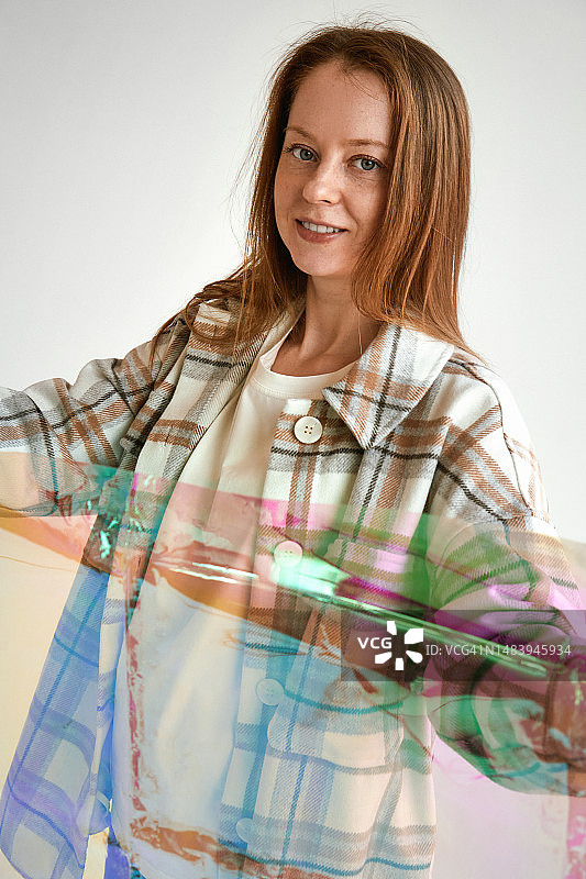 年轻有魅力的棕发女子拿着彩色胶片，活力健康生活平衡概念图片素材