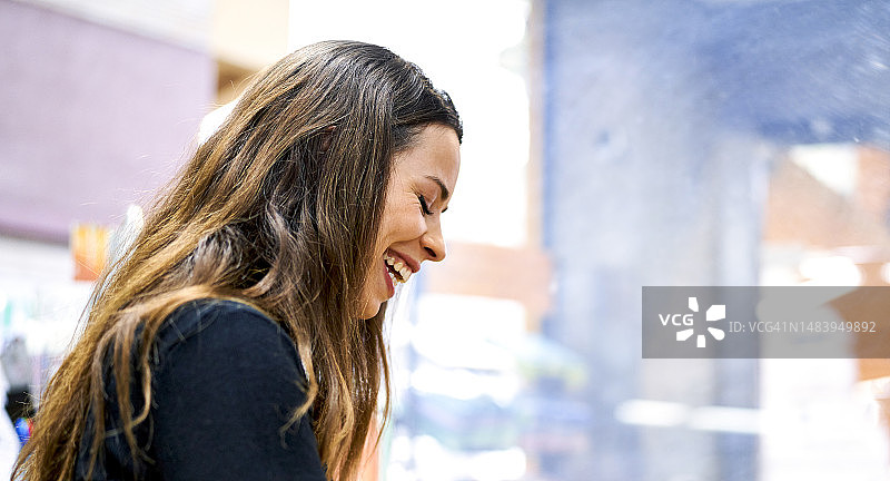 年轻女子闭着眼睛在工作中放松欢笑图片素材