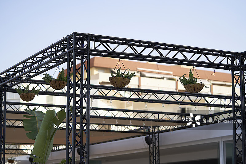 房屋外的金属结构，悬挂着植物篮，侧视图图片素材
