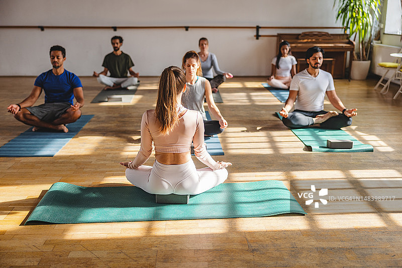白人瑜伽教练指导学员冥想图片素材