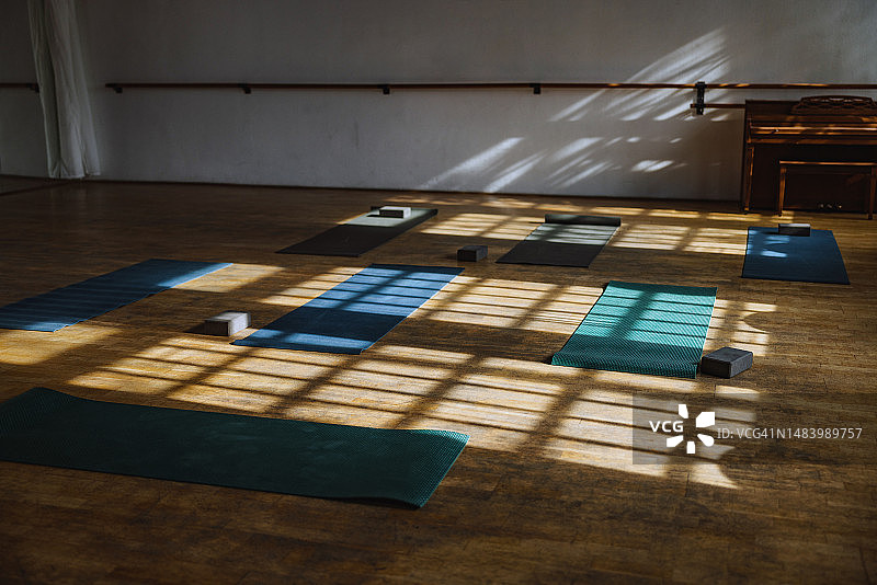 阳光照亮瑜伽馆中展开的垫子图片素材