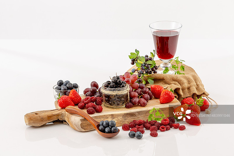 白色背景下的木制砧板上的葡萄汁图片素材