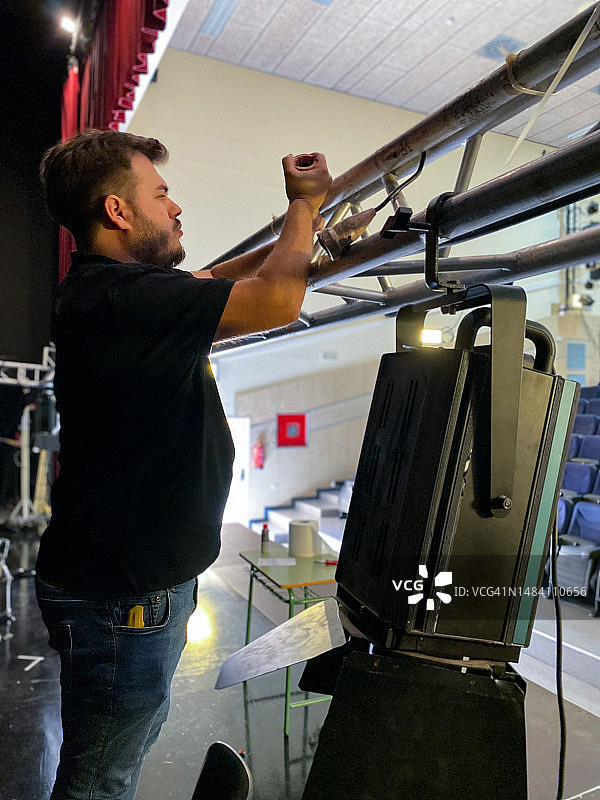 灯光师在剧院舞台上安装聚光灯图片素材