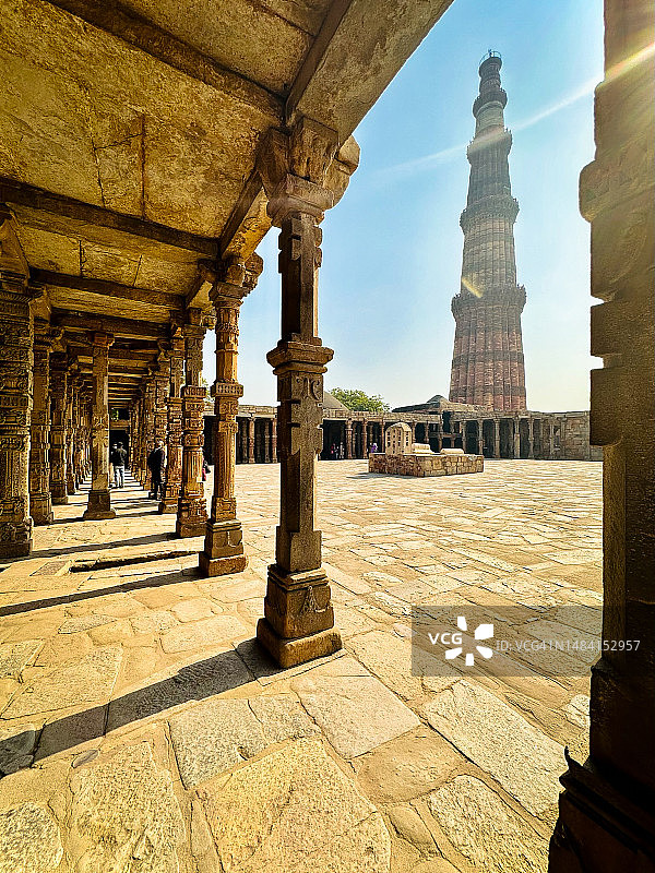 傍晚的德里顾特卜塔，前景是耆那教和印度教寺庙的古代遗迹图片素材