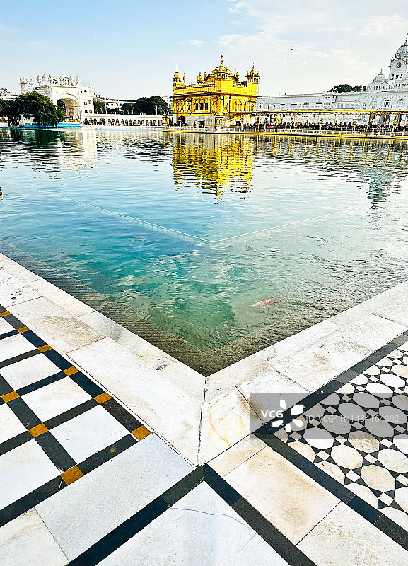 从环绕水体的道路看金色寺庙图片素材