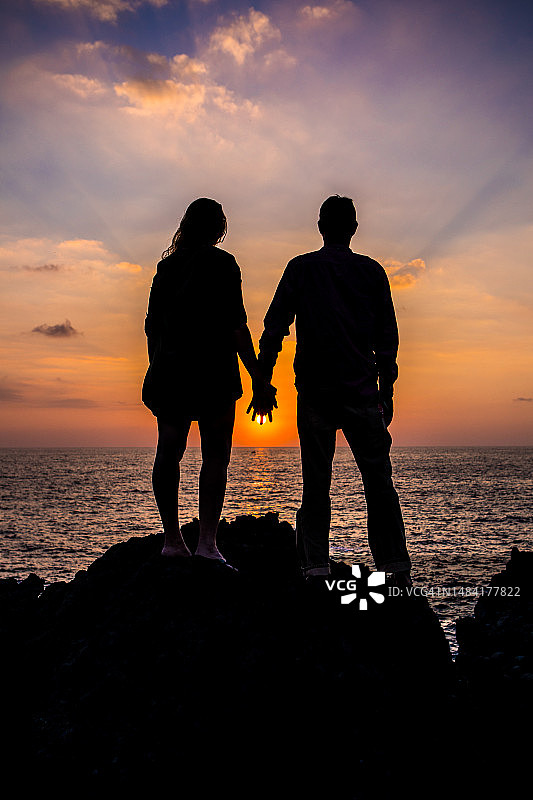 日落时分，相爱的情侣牵手剪影图片素材