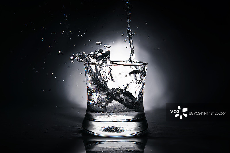 冰块溅入盛满水的玻璃杯中图片素材