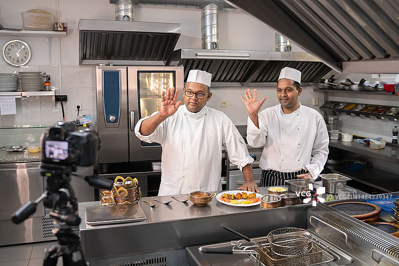 两名职业厨师向镜头挥手图片素材