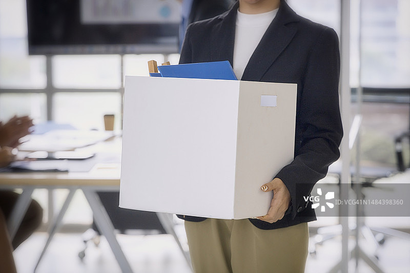 商业概念：失业者带着纸箱走出办公室图片素材