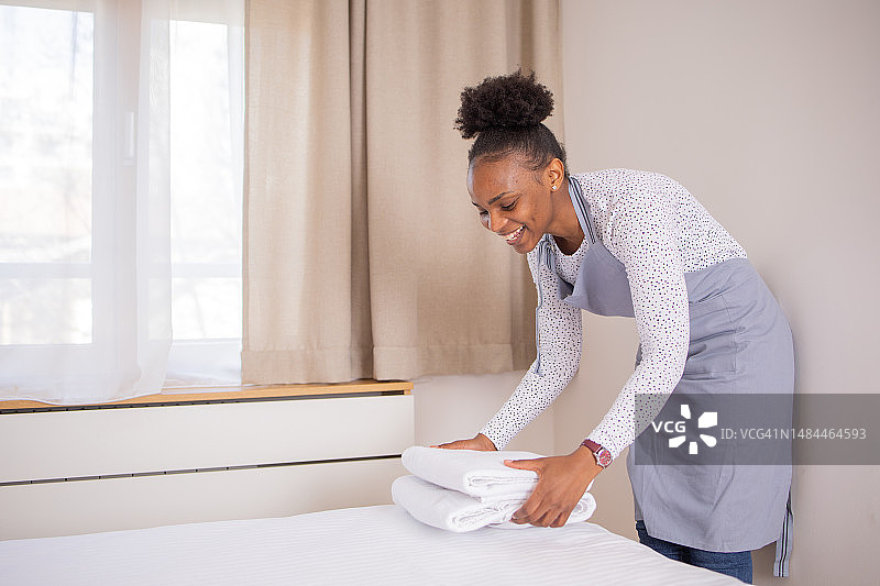 女人在酒店房间更换床单图片素材