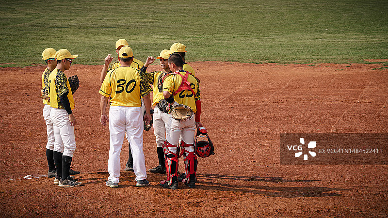 棒球教练在投手丘上向球员讲解策略图片素材