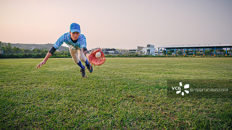 棒球比赛中，内场队员飞身接球成功的广角镜头图片素材