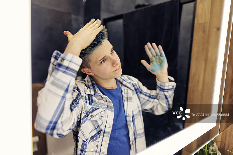 青少年男孩准备在现代化的黑暗浴室里外出图片素材