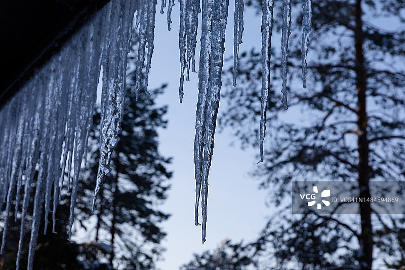 冬季芬兰卡亚尼附近奥卢湖冰封湖面上的小屋巨型冰柱图片素材