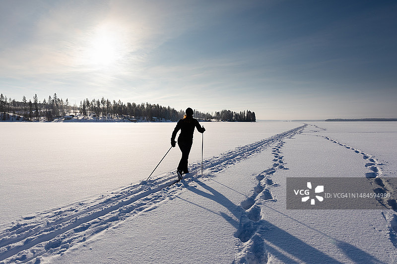 在芬兰凯努区奥卢湖冰冻湖面上滑雪的女人图片素材