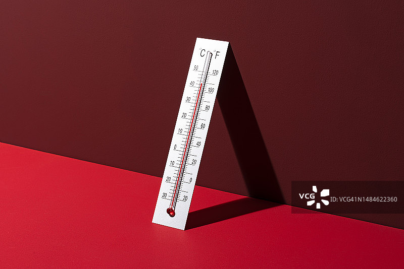 红色背景上的高温银色温度计图片素材