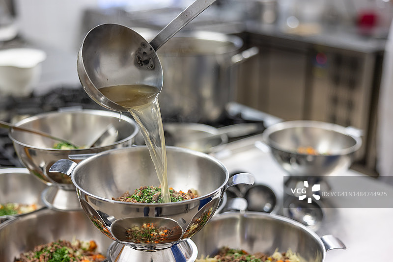 商业厨房里的勺子和汤碗图片素材