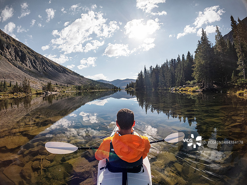 男子在科罗拉多州布雷肯里奇湖上划皮划艇的背影图片素材
