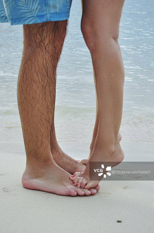牙买加海滩上赤脚女子站在男子脚上的特写图片素材