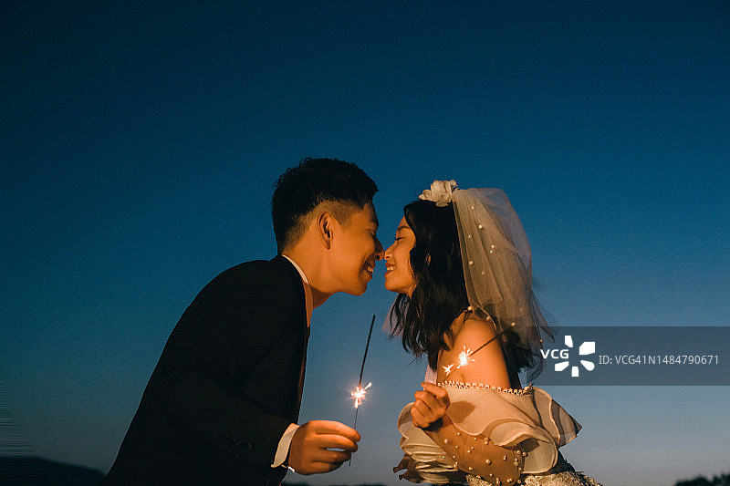 在烟花下接吻的新婚夫妇图片素材