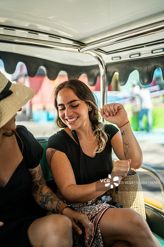 女游客朋友们在当地出租车上旅行时跳舞图片素材
