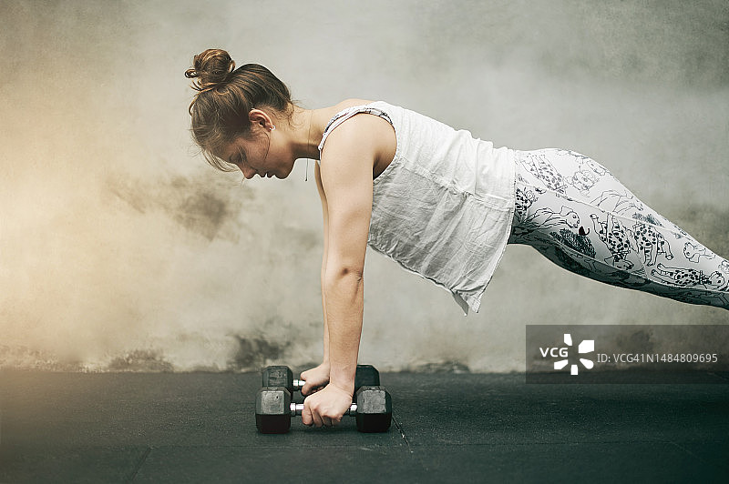 健身：在城市背景下做俯卧撑的女性图片素材